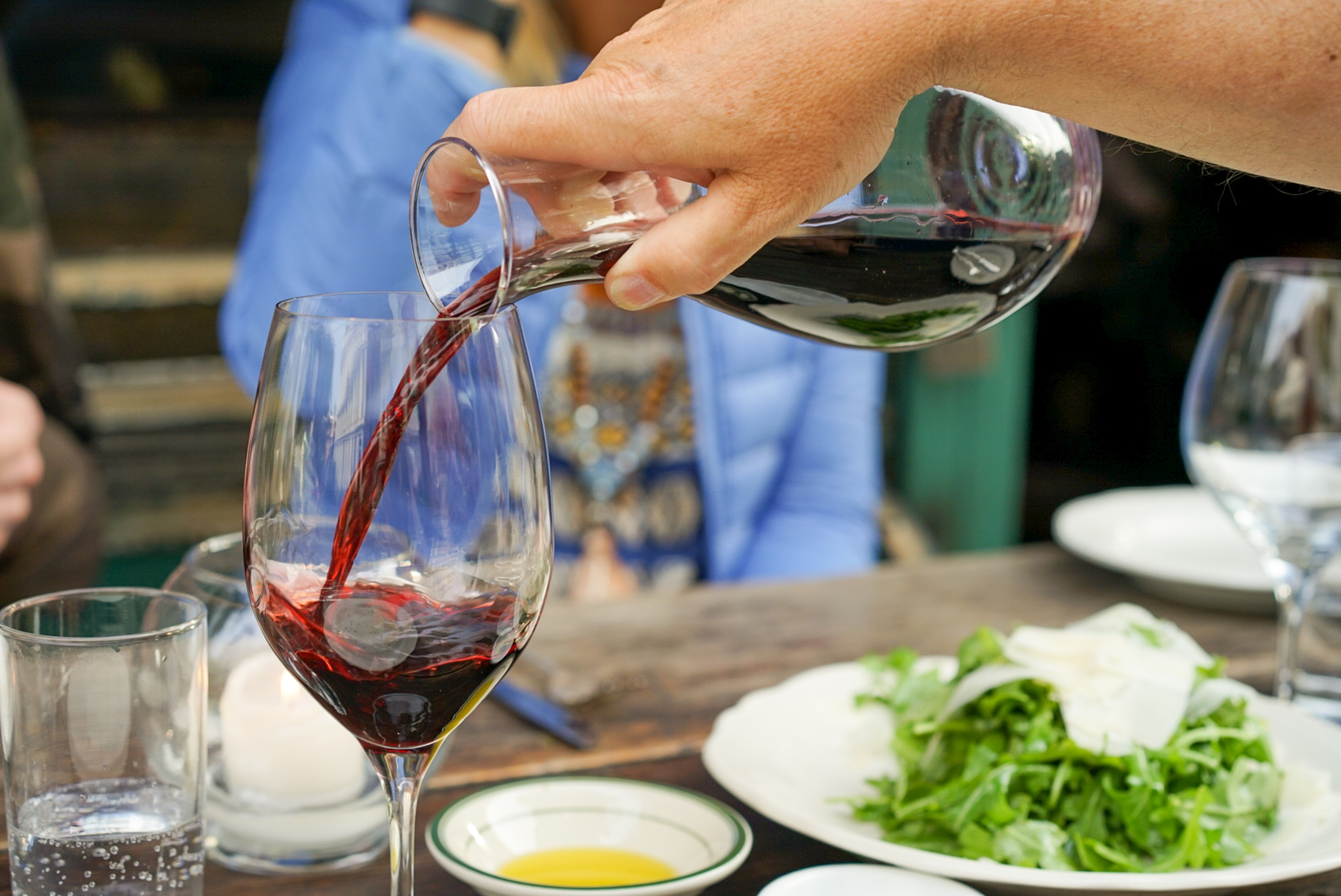 person-pouring-red-wine-on-wine-glass-2448729